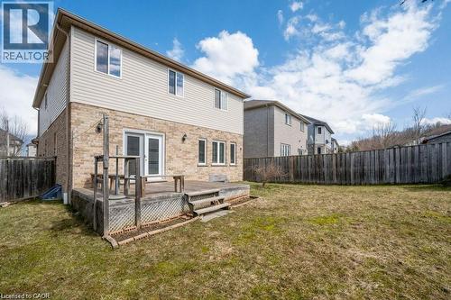 Back of house with a deck, a fenced backyard, and stone siding - 609 Woolgrass Avenue, Waterloo, ON - Outdoor