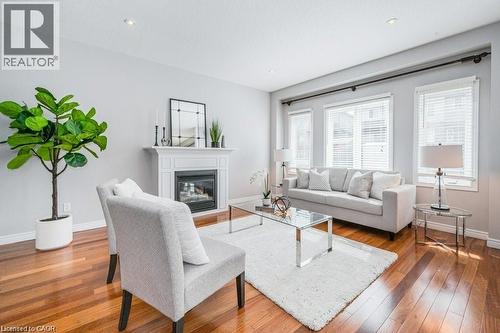 Living area with a glass covered fireplace and wood-type flooring - 609 Woolgrass Avenue, Waterloo, ON - Indoor Photo Showing Living Room With Fireplace