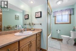 Full bathroom featuring light tile patterned floors, vanity, and shower / bath combination with glass door - 