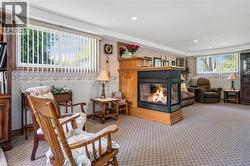 Living area featuring a multi sided fireplace, carpet, and recessed lighting - 