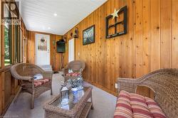 Living area with wood walls, carpet floors, and recessed lighting - 