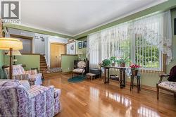 Sitting room with wood-type flooring and stairs - 
