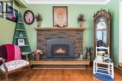 Sitting room featuring a fireplace and wood finished floors - 