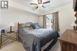 Carpeted bedroom featuring a ceiling fan - 