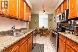 Kitchen featuring appliances with stainless steel finishes, brown cabinets, a ceiling fan, and decorative backsplash - 