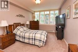 Bedroom with light carpet and baseboard heating - 
