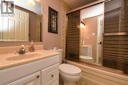 Full bath featuring vanity and enclosed tub / shower combo - 