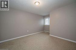 Spare room with a textured ceiling and light carpet - 