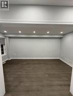 Below grade area with dark wood-style floors and recessed lighting - 