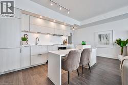 Kitchen featuring a kitchen breakfast bar, dark wood finished floors, modern cabinets, and a center island - 