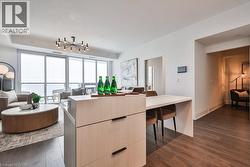 Kitchen featuring light brown cabinetry, modern cabinets, dark wood-style floors, open floor plan, and light countertops - 