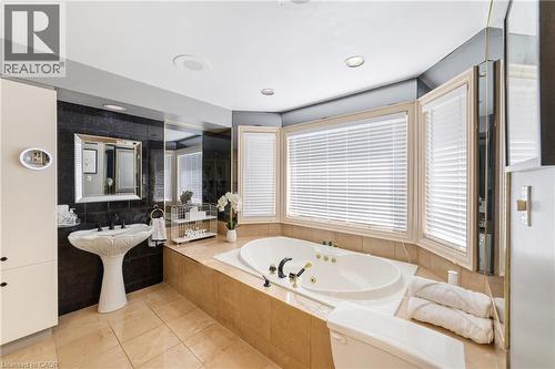 Soaker jet tub, oversized windows, added cabinet for linen storage, recessed lighting - 7775 St. Augustine Crescent, Niagara Falls, ON - Indoor Photo Showing Bathroom