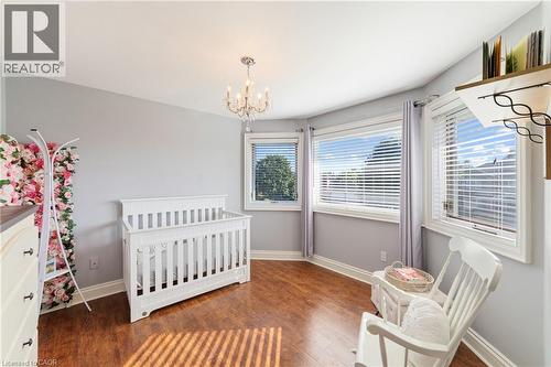 3rd bedroom with a chandelier, wood finished floors, 3 windows for lots of natural light, full-sized closet, intercom - 7775 St. Augustine Crescent, Niagara Falls, ON - Indoor Photo Showing Bedroom