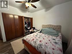 Bedroom featuring a closet, dark wood-style floors, and ceiling fan - 