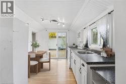 Kitchen featuring white cabinets, white electric range, light wood-style floors, healthy amount of natural light, and vaulted ceiling - 