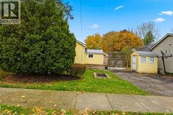 View of front of home featuring a front yard and a storage shed - 