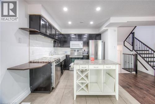 Kitchen with open shelves, backsplash, appliances with stainless steel finishes, light stone counters, and recessed lighting - 20 Bankside Drive, Kitchener, ON - Indoor Photo Showing Kitchen With Upgraded Kitchen