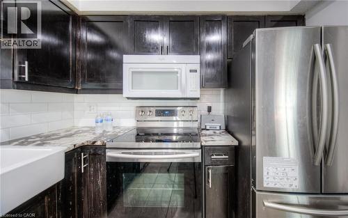 Kitchen featuring appliances with stainless steel finishes, tasteful backsplash, and light stone counters - 20 Bankside Drive, Kitchener, ON - Indoor Photo Showing Kitchen With Upgraded Kitchen