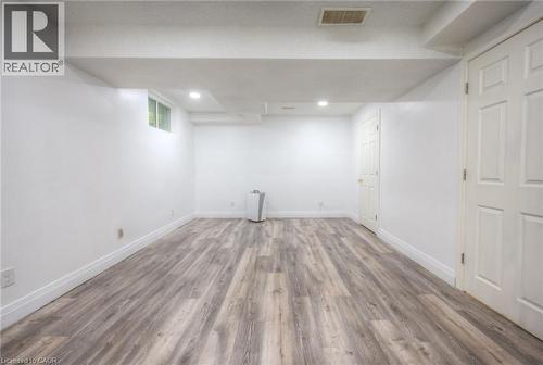 Finished below grade area featuring wood finished floors and baseboards - 20 Bankside Drive, Kitchener, ON - Indoor Photo Showing Other Room