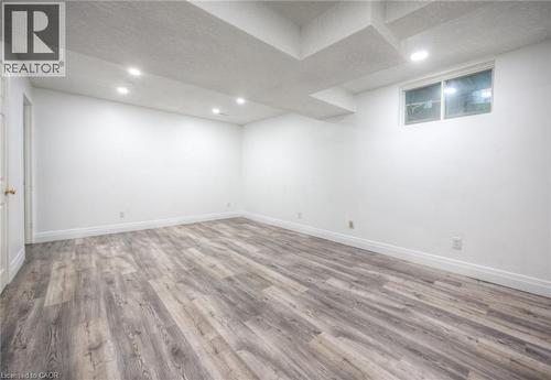 Finished basement featuring a textured ceiling, light wood-type flooring, and recessed lighting - 20 Bankside Drive, Kitchener, ON - Indoor