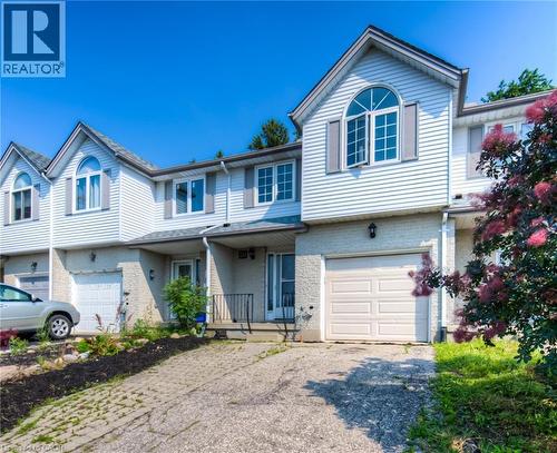 Traditional home with driveway, a garage, a porch, and brick siding - 20 Bankside Drive, Kitchener, ON - Outdoor With Facade
