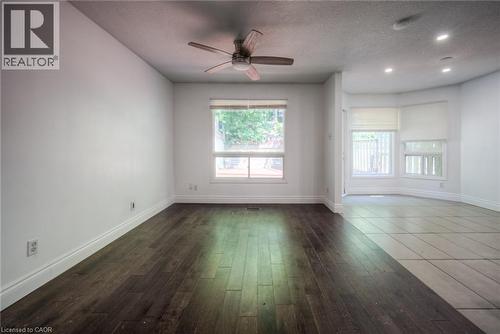 Spare room featuring dark wood-style floors, a textured ceiling, healthy amount of natural light, ceiling fan, and recessed lighting - 20 Bankside Drive, Kitchener, ON - Indoor Photo Showing Other Room