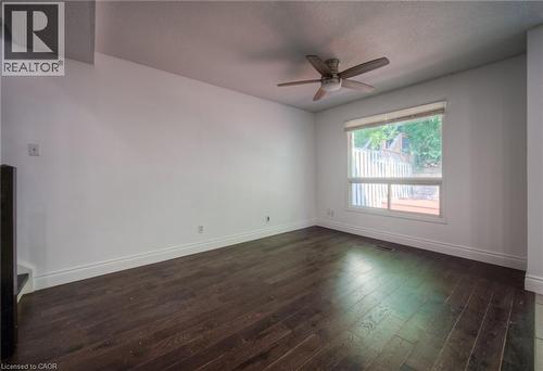 Spare room featuring dark wood-type flooring, a ceiling fan, and a textured ceiling - 20 Bankside Drive, Kitchener, ON - Indoor Photo Showing Other Room