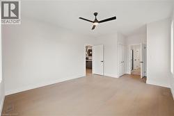 Unfurnished bedroom with light hardwood flooring, a closet, and a ceiling fan - 