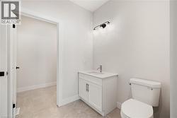 Bathroom with vanity and light tile patterned floors, with access to laundry room - 