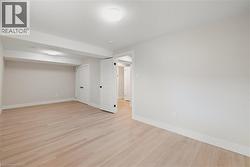 Basement with light hardwood flooring and baseboards - 
