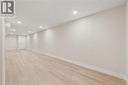 Finished basement with recessed lighting and light hardwood flooring - 