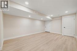 Finished basement with recessed lighting and light hardwood flooring - 