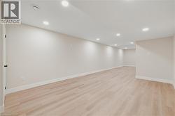 Finished basement featuring recessed lighting and light hardwood flooring - 