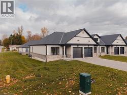 Side view of end-unit with concrete driveway, a front yard, and board and batten siding - 