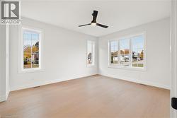 Primary bedroom featuring light hardwood flooring and a ceiling fan - 
