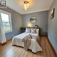 Bedroom featuring light wood-style floors and baseboards - 