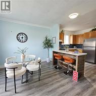 Kitchen with freestanding refrigerator, tasteful backsplash, brown cabinets, light wood finished floors, and a kitchen breakfast bar - 