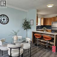 Dining area featuring dark wood finished floors and crown molding - 