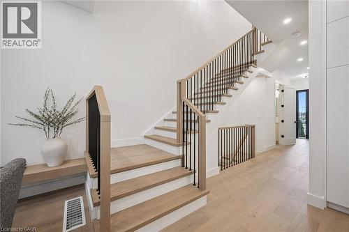 White oak stair case with iron spindles to the second floor. - 548 Peach Blossom Court, Kitchener, ON - Indoor Photo Showing Other Room