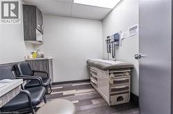 Office space featuring a drop ceiling and dark wood-style floors - 