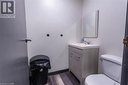 Half bathroom featuring vanity and dark wood-type flooring - 