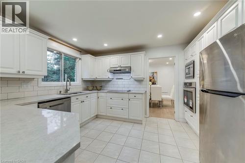 Kitchen with appliances with stainless steel finishes, light stone countertops, white cabinetry, light tile patterned flooring, and recessed lighting - 170 Cavendish Court, Oakville, ON - Indoor Photo Showing Kitchen