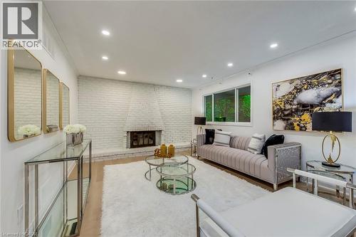 Living area featuring wood finished floors, a brick fireplace, recessed lighting, and brick wall - 170 Cavendish Court, Oakville, ON - Indoor Photo Showing Living Room With Fireplace