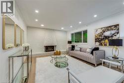 Living area featuring wood finished floors, a brick fireplace, recessed lighting, and brick wall - 