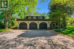 View of front of property featuring driveway, brick siding, and an attached garage - 