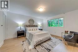 Bedroom with light wood-style floors and baseboards - 
