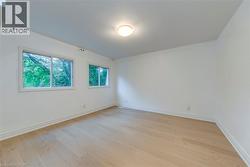 Spare room featuring baseboards and light wood-style floors - 