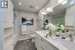 Bathroom featuring double vanity, dark wood-type flooring, recessed lighting, and tiled shower / bath - 