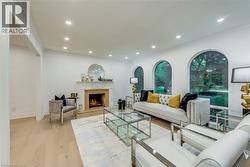 Living area with a premium fireplace, light wood-style floors, recessed lighting, and crown molding - 