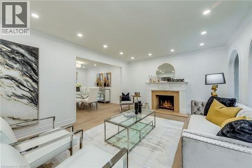Living area with crown molding, a high end fireplace, light wood-style flooring, recessed lighting, and arched walkways - 170 Cavendish Court, Oakville, ON - Indoor Photo Showing Living Room With Fireplace